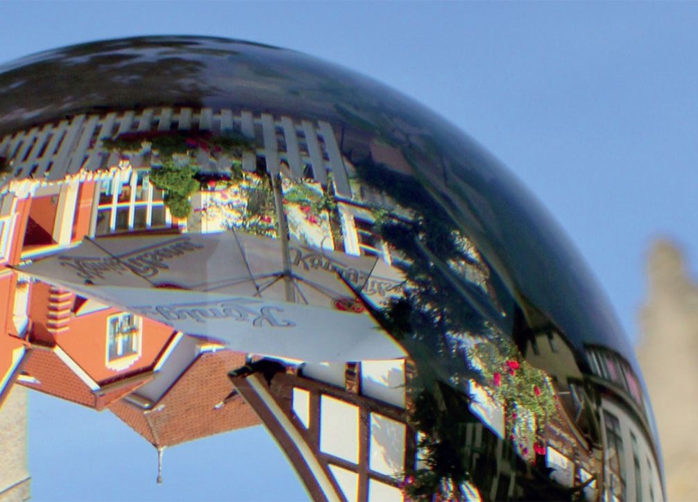 Häuser auf einer Glaskugel als Spiegelbild zu sehen