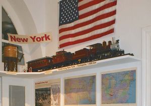 Themenbereich New York mit verschiedenen Karten, Ausstellungsstücken und einer Fahne