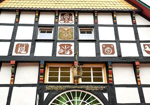 Vorderansicht von einem Fachwerkhaus mit Fenstern und einer großen Tür