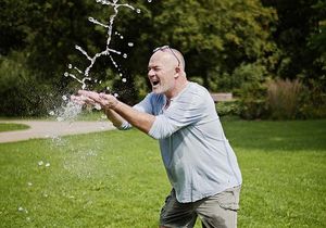 Ein Mann hält seine Hände unter einen Wasserstrahl